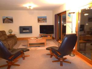 a living room with two chairs and a couch at The Burrow at Woodlands in Newquay