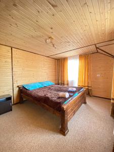a bedroom with a large bed in a wooden room at Краєвид in Vorokhta