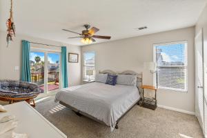 The Vista of Palm Beach في جالفيستون: غرفة نوم بسرير ومروحة سقف
