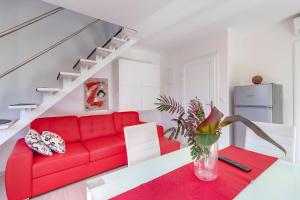 a living room with a red couch and stairs at Apartment Karin in Veli Lošinj