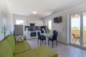 a living room with a couch and a table with chairs at Apartment Karin in Veli Lošinj