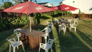 a group of tables and chairs with red umbrellas at Cabañas Diamante in Gualeguaychú