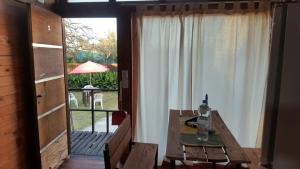 a dining room with a wooden table and a window at Cabañas Diamante in Gualeguaychú