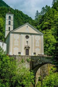 una iglesia en lo alto de un puente con un edificio en Grotto Zendralli, en Roveredo