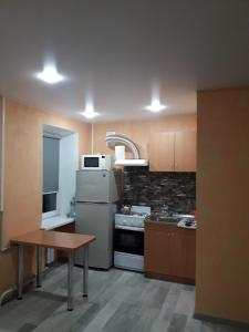 eine Küche mit einem Kühlschrank und einem Tisch darin in der Unterkunft Квартира студіо біля Автовокзалу in Krementschuk