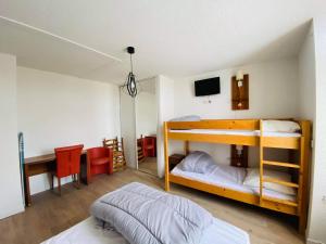 une chambre avec deux lits superposés et un bureau dans l'établissement Résidence Bardon-Perry, à Le Mont-Dore