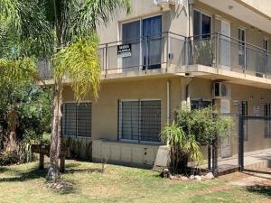 a building with a palm tree in front of it at Apart Altos del Golf in Colón