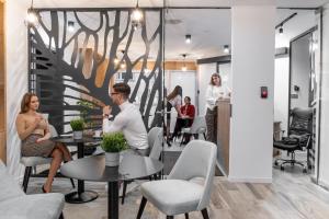 un groupe de personnes assises à des tables dans une pièce dans l'établissement Minaret Residence & Relax Pécs, à Pécs