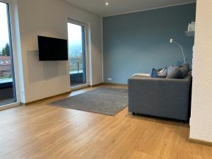 Il comprend un salon doté d'un canapé et d'une télévision à écran plat. dans l'établissement Helle Dachgeschosswohnung in Bockhorn, LK Friesland, à Bockhorn