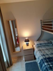 a bedroom with a bed and a mirror at Beachside Holiday Home in Portrush