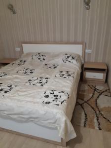 uma cama com lençóis pretos e brancos em Квартира Центр em Vinnytsya