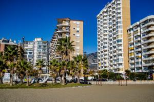 フエンヒロラにあるFuengirola playa beachfrontのヤシの木と高い建物のある都市