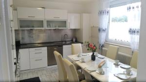 cocina con mesa con sillas y comedor en Große 130qm Ferienwohnung mit Whirlpool, en Sulzbach