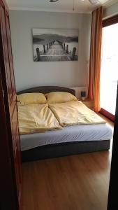 een bed in een slaapkamer met een foto aan de muur bij Jenny apartman Siófok in Siófok