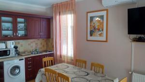 een keuken met een tafel en stoelen en een magnetron bij Jenny apartman Siófok in Siófok