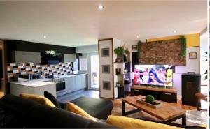 uma sala de estar com um sofá, uma televisão e uma cozinha em Apartment Design Suite em Jehanster