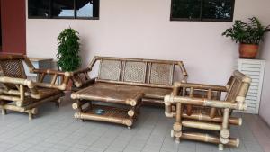 a group of wooden furniture sitting next to a wall at Jinhold Service Apartment Miri in Miri