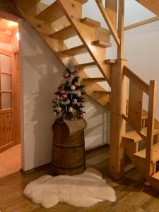 ein Weihnachtsbaum auf einem Fass unter einer Treppe in der Unterkunft Domček u Fera in Zázrivá