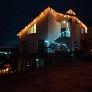 uma casa com luzes de Natal ao lado dela em Сімейний відпочинок em Truskavets