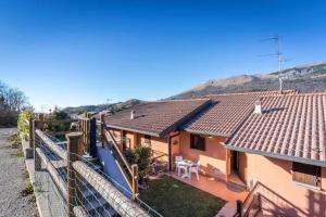 a view of a house with mountains in the background at Casa Vacanze Rosalba in Ferraro di Monte Baldo