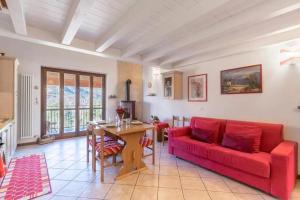 sala de estar con sofá rojo y mesa en Casa Vacanze Rosalba, en Ferraro di Monte Baldo
