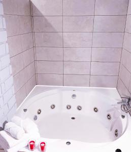 a white bath tub in a bathroom with red soda cans at El Castillo in Alcalá de Guadaira