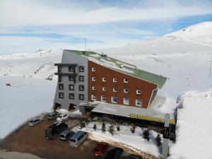 a building in the snow with cars parked in front of it at ERCİYES HİLL in Erciyes