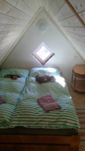 łóżko z niebieską i zieloną pościelą na poddaszu w obiekcie Chaloupka Albrechtice w mieście Albrechtice v Jizerských horách