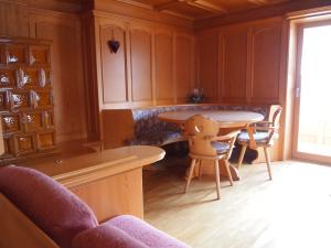 eine Küche mit einem Tisch und Stühlen im Zimmer in der Unterkunft Ciasa Giorgina in Pozza di Fassa