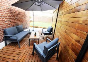 a patio with chairs and a table and an umbrella at COSY APPART - HYPER CENTRE - TRAMWAY - TERRASSE - leRelaisdOdile3 in Valenciennes