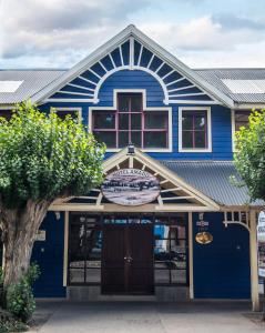 un edificio azul con un cartel delante en Hotel Amado en El Calafate