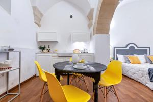 a kitchen and living room with a table and yellow chairs at Yellow Loft - Old Town Apartment SIT in Lecce