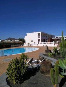 ein Schwimmbad mitten in einem Ferienresort in der Unterkunft Casita Mary in Costa Teguise