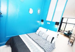 a blue bedroom with a bed with a blue wall at COSY APPART - HYPER CENTRE - TRAMWAY - TERRASSE - leRelaisdOdile3 in Valenciennes