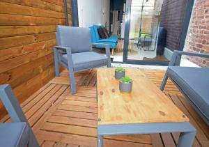 a patio with a table and chairs on a deck at COSY APPART - HYPER CENTRE - TRAMWAY - TERRASSE - leRelaisdOdile3 in Valenciennes