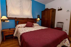 a bedroom with a bed with a red comforter at Casa Laiglesia in Uncastillo