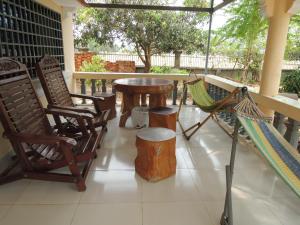 a porch with chairs and a table and a hammock at Meas Family Homestay in Angk Ta Saom