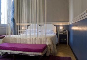ジェノヴァにあるHotel Colombo Genovaのベッドルーム(大型ベッド1台、紫色のベンチ付)