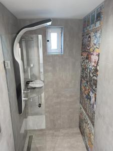 uma casa de banho com um chuveiro e um mural na parede em Artemis Boutique House em Artemida