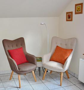 two chairs with a red pillow in a room at Gîte La Maison Bleue in Bergheim