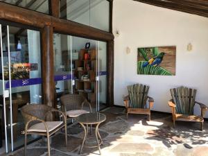 a room with chairs and a table and a painting at Pousada Recreio Da Praia in Abraão