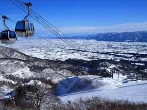 um teleférico que sobrevoa uma montanha coberta de neve em guesthouse絲 -ito-ゲストハウスイト em Fukumitsu