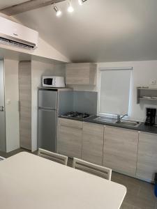 a kitchen with a table and a stove top oven at Palombaggia location i pini Porto Vecchio in Porto-Vecchio