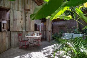 eine Terrasse mit einem Tisch und Stühlen auf einem Holzboden in der Unterkunft Casa BEE Trancoso in Trancoso