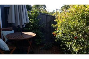 a wooden table and an umbrella on a patio at Woolloongabba, comfortable, modern, private studio in Brisbane