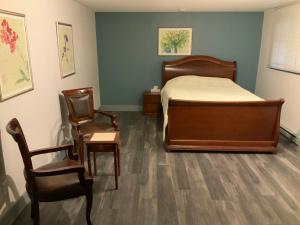 a bedroom with a bed and two chairs in a room at Alpine Inn in Valemount