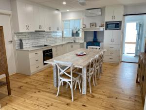 a kitchen with a wooden table and chairs in it at Salty Dog in Emu Bay
