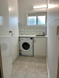 a laundry room with a washing machine and a sink at Salty Dog in Emu Bay