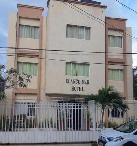 a building with a fence in front of it at Blanco Mar Hotel in Santa Marta