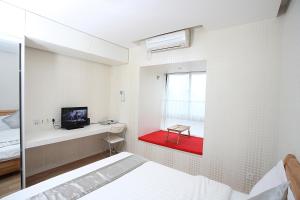 um quarto com uma cama, uma televisão e uma janela em Homy Inns Mu Ma em Nanquim